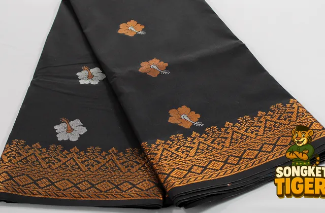 Songket fabric folded showing gold motif detail across the surface