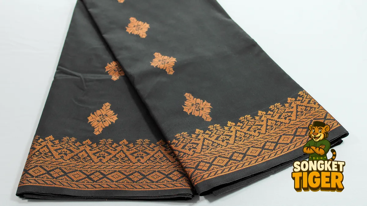 Songket fabric in deep maroon with gold thread motifs