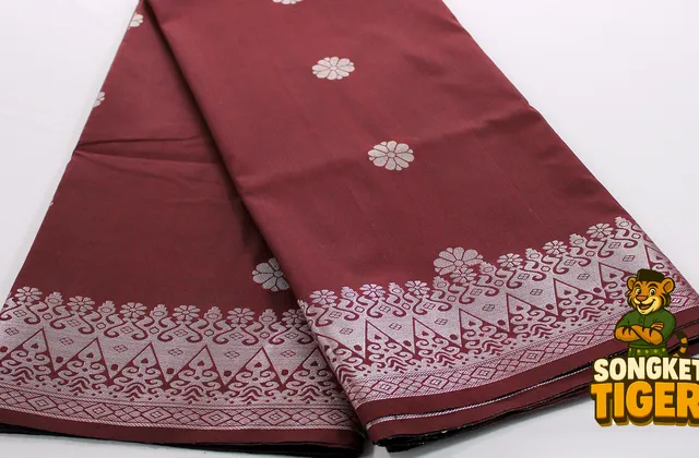 Luxurious songket fabric with dense gold thread pattern catching light
