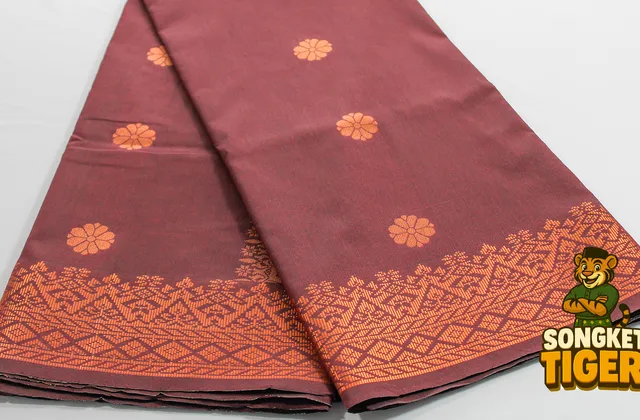 Detailed view of a repeating gold songket pattern woven across black fabric