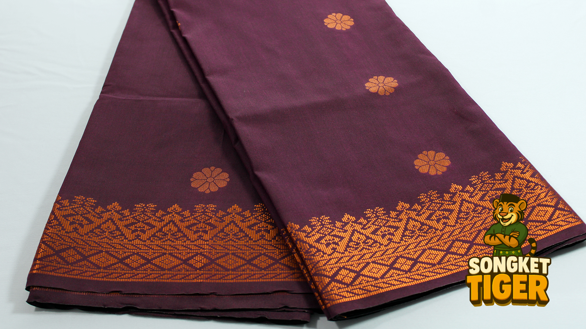 Songket tenun with intricate gold border and floral patterns